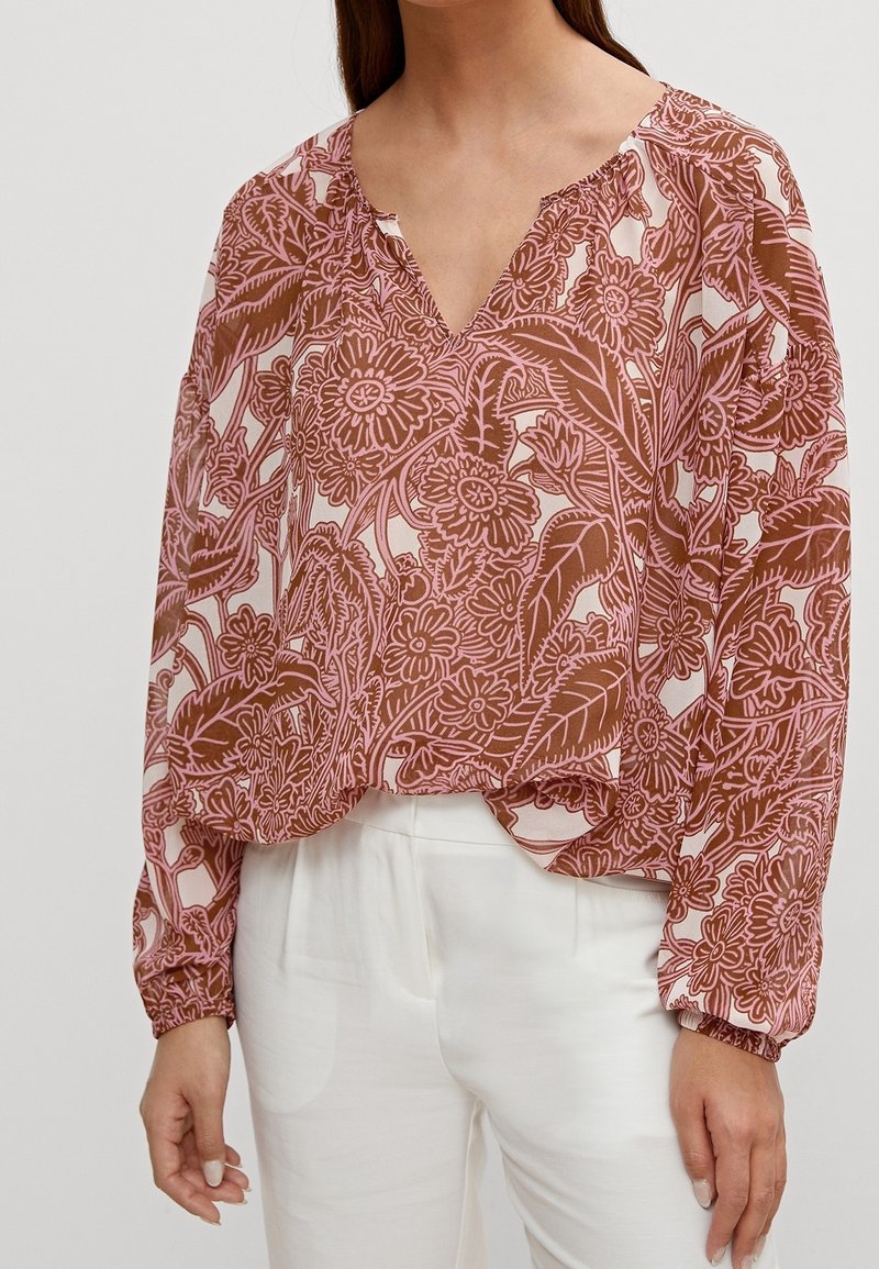 Vloeiende blouse met lange mouwen in een warme roze en bruine bloemenprint. V-hals met geplooide accenten bij de mouwen. Lichtgewicht, semi-transparant materiaal.