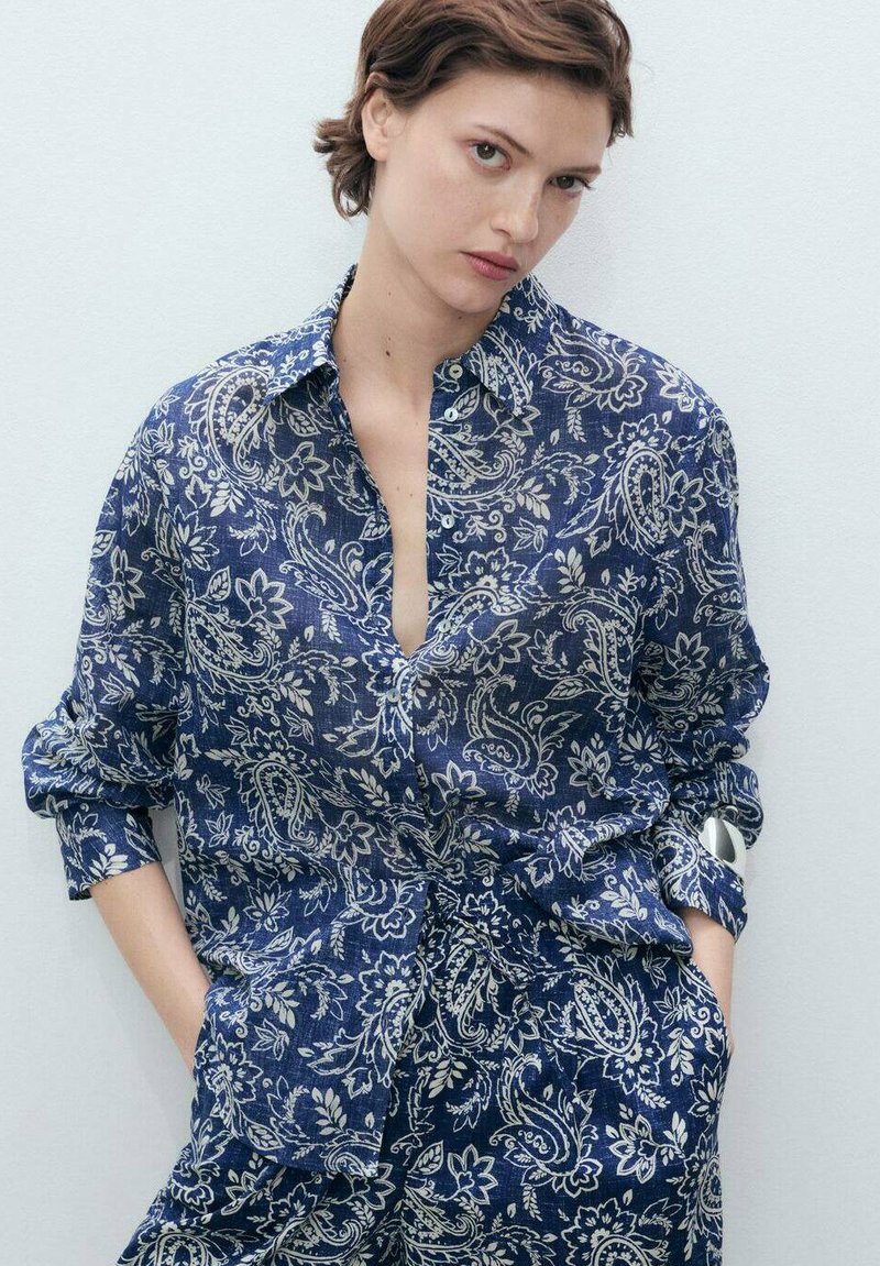 Camicia a maniche lunghe blu navy con motivo paisley. Realizzata in tessuto leggero, con maniche arrotolabili e una vestibilità rilassata.