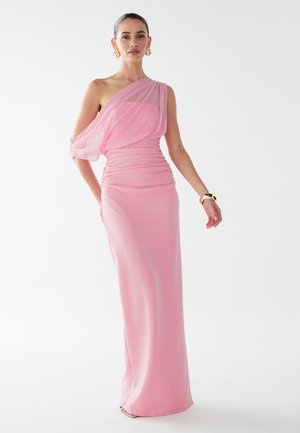 One-shoulder lyserød kjole med samlet tekstur, flydende chiffon-overlag, gulvlængde design og en tætsiddende silhuet. Guldbelagt armbånd som accent.