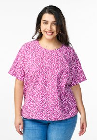 Blusa rosa a maniche corte con un motivo floreale in bianco e rosa chiaro. Girocollo e vestibilità comoda.