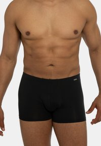 Boxer shorts neri con un design aderente, vita elastica e texture liscia, caratterizzati da un logo discreto sul davanti.