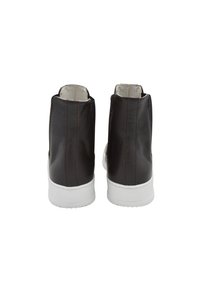 Botas de piel marrón hasta el tobillo con un diseño elegante, suela de goma blanca y detalles de costura visibles. Textura suave y estilo simple.
