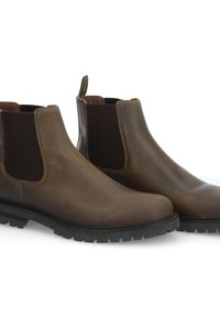 Bottines Chelsea en cuir marron avec panneaux latéraux élastiques, bout rond et semelle en caoutchouc robuste. Texture lisse avec des accents noirs contrastants.