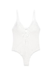 Vitt spetsbodysuit med tunna axelremmar, djup V-ringning och snörning framtill. Har ett blommönster och scallopade kanter.