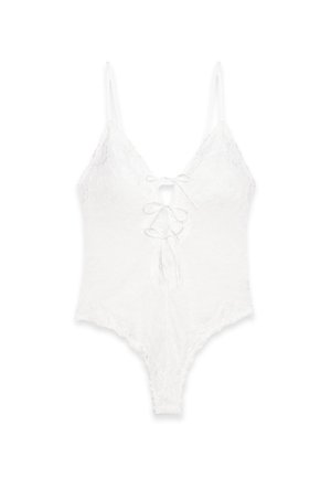 Body in pizzo bianco con spalline sottili, un profondo scollo a V e una chiusura a lacci sul davanti. Presenta un motivo floreale e bordi scallop.