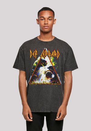 Black oversized cotton t-shirt featuring a colorful graphic design with "Def Leppard" text and a triangular pattern in the center.