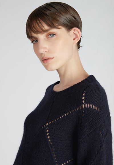 Marineblauer Strickpullover mit lockerem Schnitt, der offene Rautenmuster, einen gerippten Ausschnitt und eine strukturierte Oberfläche aufweist. Weiches, leichtes Material.