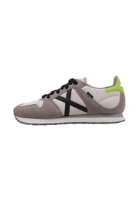 Sneakers with a grey suede and white leather upper, featuring a black diagonal stripe, black laces, and a neon green heel accent.