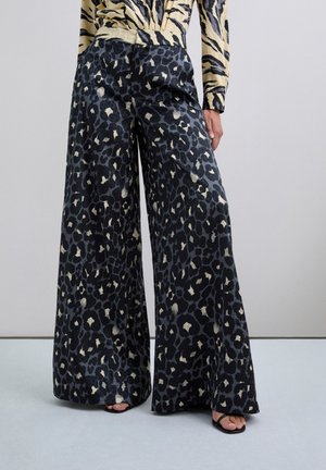 Pantalones de pierna ancha en tejido negro con un estampado de leopardo, que cuentan con una superficie texturizada y un ajuste cómodo.