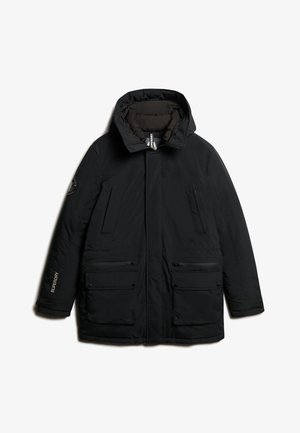 Parka negra aislante con capucha, con cierre de cremallera, cuatro bolsillos delanteros y un acento del logotipo en la manga. Textura de tela suave.