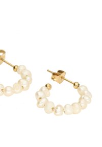 Boucles d'oreilles en or en forme de créoles ornées de perles blanches irrégulières, mettant en valeur une finition polie et un design de fermoir robuste.