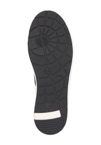 Schwarze Gummisohle mit strukturiertem Grip-Muster und weißen Akzenten entlang der Kante. Runde und hexagonale Formen sind im Profildesign zu erkennen.