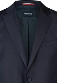 Marineblazer aus strukturiertem Stoff. Verfügt über einen einzigen Knopfverschluss, mit Schößchen und einem gemusterten Innenfutter. Etikett: Hechter Paris.