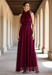 Burgunderfarbenes Kleid mit Neckholder, plissiertem Oberteil, Empire-Taille und mehrlagigem Rock. Getragen mit schwarzen Stiletto-Sandalen und Hängeohrringen.