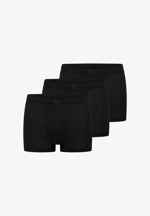 Tre sorte boxershorts til mænd stablet, med elastiske taljebånd og sidenetpaneler for åndbarhed.