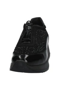 Scarpe sportive nere con una superficie testurizzata, punta in vernice liscia e decorazioni in perline lungo la parte superiore. Suola con battistrada circolare.