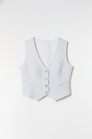 Gilet rayé blanc avec un profond décolleté en V, cinq boutons et deux poches devant. Tissu lisse avec une texture subtile et des lignes verticales.