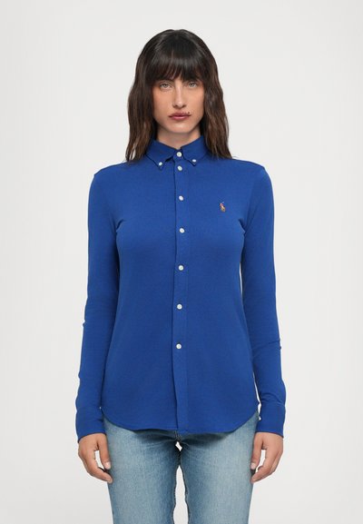 Camicia azzurra a maniche lunghe realizzata in tessuto testurizzato, con colletto alla francese e un piccolo logo ricamato sul petto.