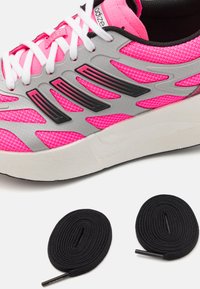 Športová obuv s ružovou sieťovinou, striebornými detailmi a čiernymi akcentmi. Obsahuje dve čierne okrúhle šnúrky s plastovými koncami.