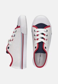 Zapatillas de lona blancas con acentos en rojo y azul marino, puntera redonda, cordones blancos y suela de goma texturizada con un detalle a rayas.