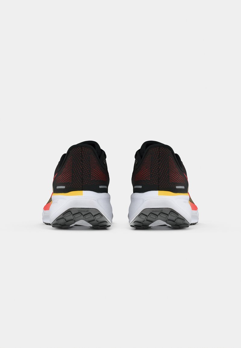 Scarpe da corsa nere con accenti rossi e gialli, dotate di una parte superiore testurizzata, colletto imbottito e intersuola bianca con suola in gomma a motivo.