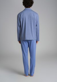 Pigiama a righe blu composto da una camicia button-up a maniche lunghe e pantaloni coordinati, realizzati in tessuto morbido e leggero, con una vestibilità comoda.
