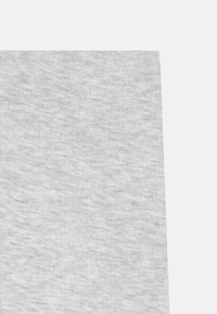 Tissu grisé à côtes avec un motif subtilement tacheté. La texture est douce et le matériau semble extensible et léger.