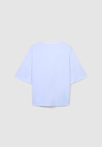 Jasnoniebieska koszulka z krótkim rękawem o luźnym kroju, okrągłym dekolcie i gładkim materiale. Posiada prosty wzór bez widocznych zdobień ani elementów metalowych.