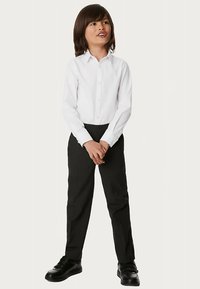 White button-up shirt, black slacks, and black shoes worn by a child. Smooth fabric, fitted design, and classic collar detail.