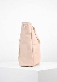 Miękka różowa skórzana torba o strukturalnym kształcie, wyposażona w zamek błyskawiczny i złote akcenty metalowe. Charakteryzuje się płaskimi bokami i zaokrąglonym dnem.