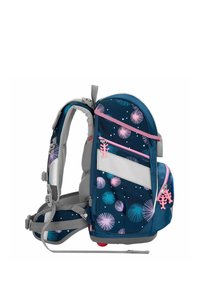 Mochila azul con acentos estampados, correas grises y múltiples bolsillos. Presenta un clip decorativo rosa y detalles reflectantes.