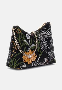 Torebka z czarnym materiałowym zewnętrznym wykończeniem zdobionym haftem kwiatowym w kolorach białym, zielonym i pomarańczowym, z akcentami w postaci srebrnego łańcuszka na ramię. Zamknięcie na suwak.