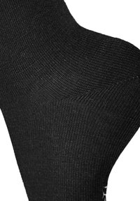 Schwarze Socke aus strukturiertem Stoff mit einem gerippten Design. Das Material ist glatt und sitzt eng am Knöchel.