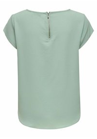 Haut vert clair à manches courtes avec un col rond et un détail de fermeture éclair à l'arrière, fabriqué en tissu texturé.