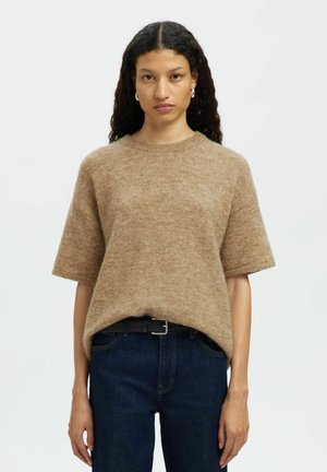Bruine, korte mouwen gebreide trui met een zachte textuur en ronde halslijn, gecombineerd met donkerblauwe jeans en een zwarte riem. Minimalistisch design, lichte stof.