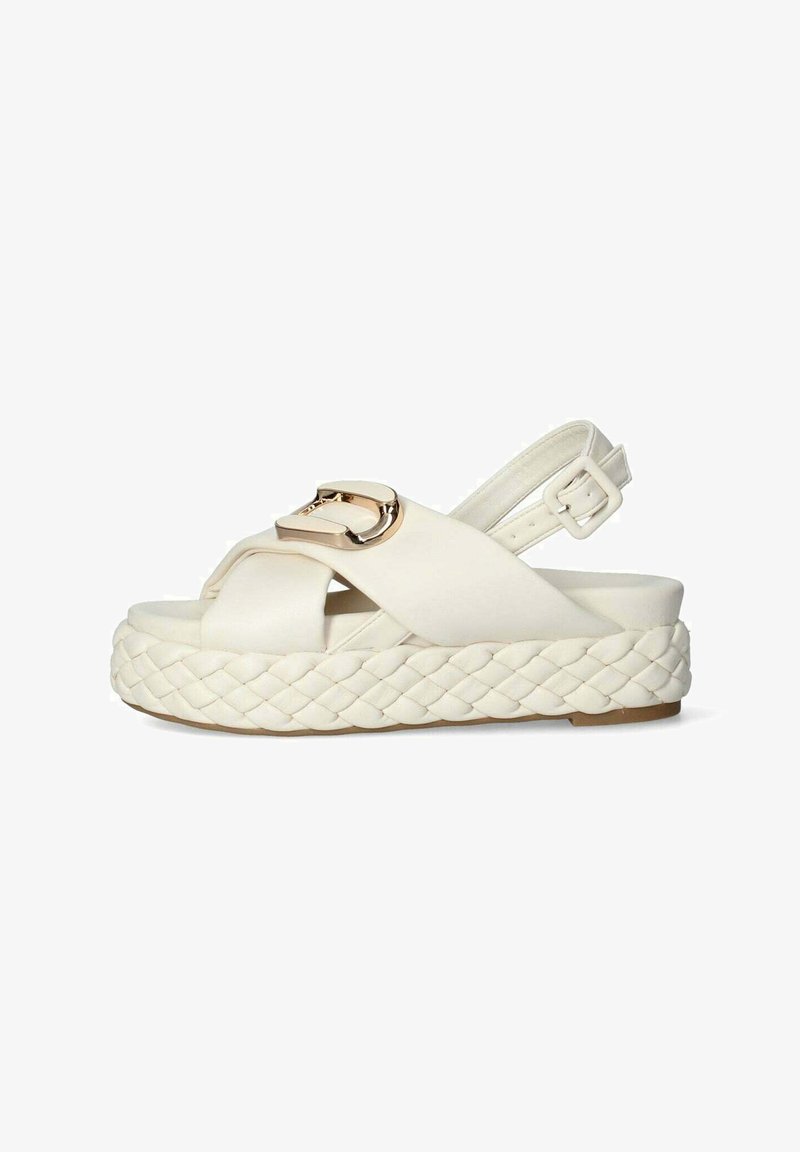 Białe skórzane sandały na koturnie z plecioną jute'ową podeszwą, z krzyżującymi się paskami i złotym zapięciem w detalu.