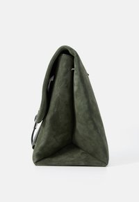 Borsa triangolare verde in suede con un design strutturato, texture morbida e tracolla regolabile. Caratterizzata da un'estetica minimalista e assenza di hardware visibile.