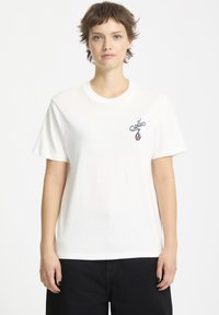 Hvid bomulds t-shirt med korte �ærmer og rund halsudskæring, prydet med et broderet design på venstre brystområde.