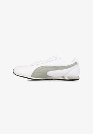 Scarpa da ginnastica bianca con tomaia in pelle liscia, accenti verdi, forma aerodinamica e suola in gomma nera. Presenta lacci e collo imbottito.