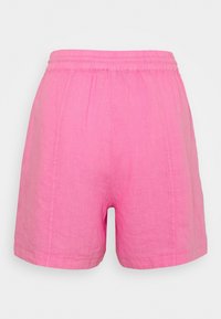 Pantalones cortos de lino rosa con una cintura elástica, que presentan un corte relajado y detalles de costura simples, diseñados para la comodidad y la transpirabilidad.