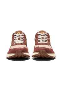 Bruna och beige sportskor med en strukturerad ovandel, vita snören, vadderad krage och gummisula med multidirektionellt grepp.