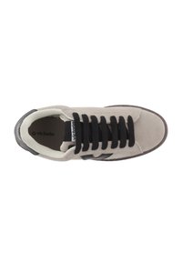 Grå mockaskor med svarta snörningar, vit insida och en svart logotyp på tungan. Har en svart accent på sidan.