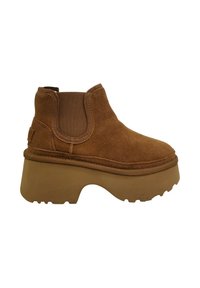 Stivaletto in suede marrone con pannelli laterali elasticizzati, suola piattaforma in gomma spessa e punta rotonda. Superficie testurizzata e dettagli con cuciture rinforzate.