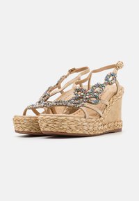 Sandali con zeppa beige con dettagli in juta intrecciata, decorati con strass colorati sulle cinghie, dotati di cinturini alla caviglia regolabili.
