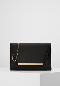 Pochette enveloppe noire en tissu lisse avec une bandoulière en chaîne dorée et une élégante barre métallique minimaliste à l'avant.