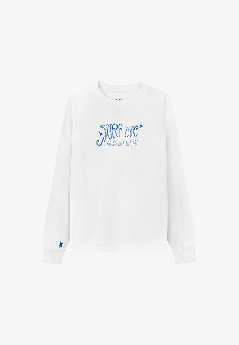 Biała koszulka z długim rękawem z niebieskim nadrukiem tekstu "SURF INC" oraz hasłem "styl życia z poparzeniem słonecznym". Posiada niebieską gwiazdkę jako akcent na rękawie.