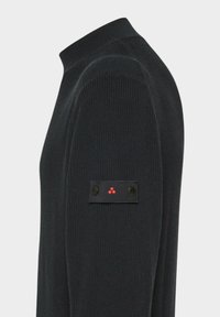 Schwarzer, gerippter Pullover mit hohem Kragen und einem Etikett am linken Ärmel, das zwei schwarze Knöpfe und ein Muster aus drei roten Punkten zeigt.