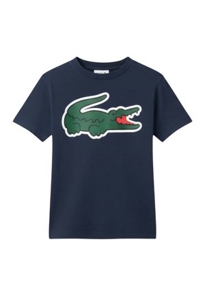 Maglietta a maniche corte blu navy con grande logo di coccodrillo verde che mostra una bocca aperta con lingua rossa al centro davanti.