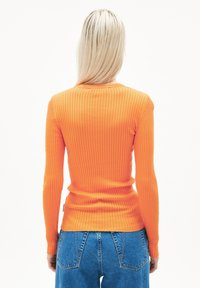 Gestreiftes Langarmtop in lebhaftem Orange, figurbetonter Schnitt, weiche Textur, mit Rundhalsausschnitt und einer leichten Taillierung.