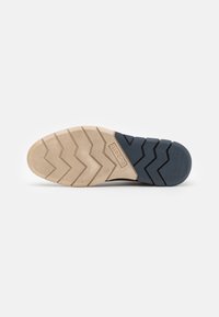 Talpa de pantof cu un model de profil în zigzag; combinație de culori bej și bleumarin; material din cauciuc texturat pentru aderență și durabilitate.